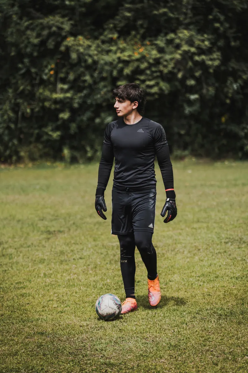 Arquero amateur con guantes y balón durante entrenamiento
