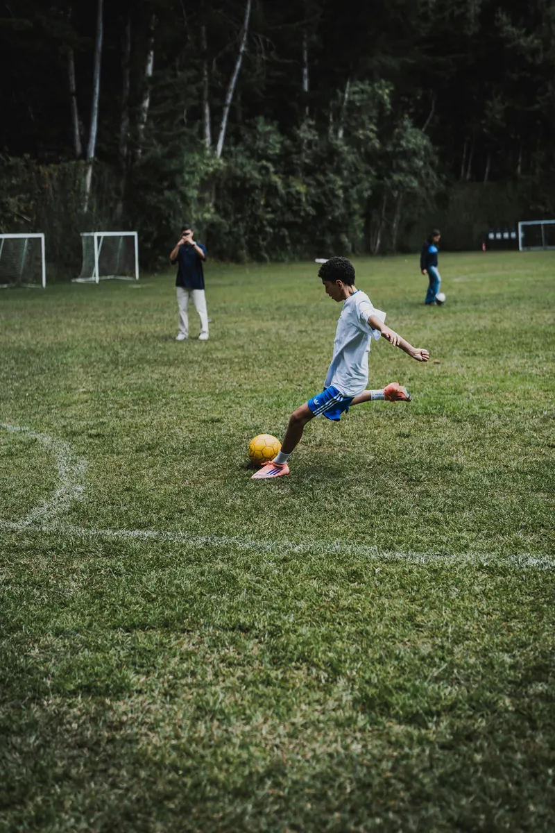 Joven futbolista pateando el balón en entrenamiento formativo