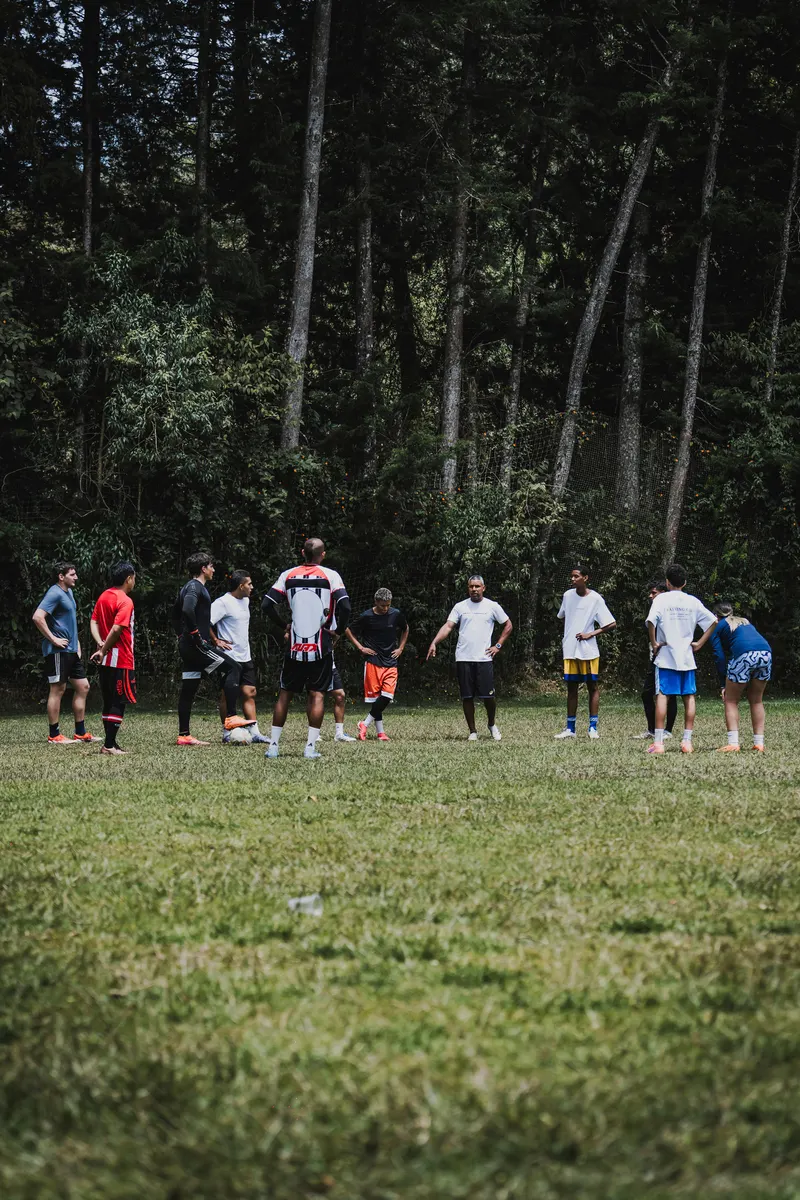 Equipo completo reunido en círculo recibiendo instrucciones del entrenador